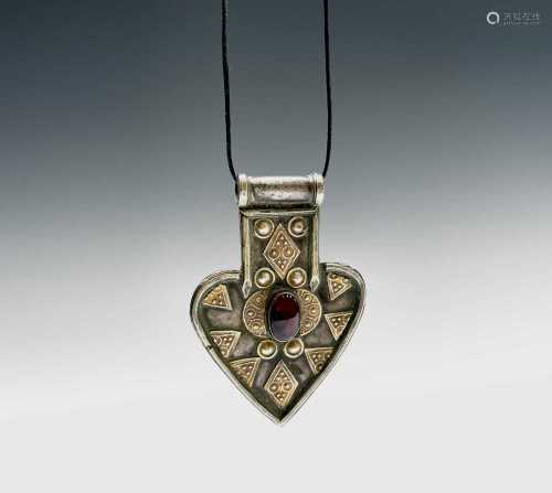 An Arabic white metal pendant,circa 1900, 8 x 5.5cm. Provena...