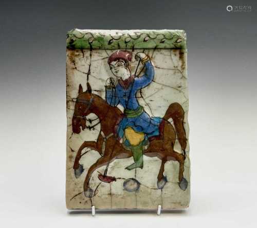 A Persian pottery tile, 19th century, depicting a figure on ...