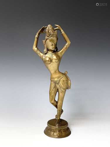 A Burmese tall brass figure of a dancer, 20th century, raise...