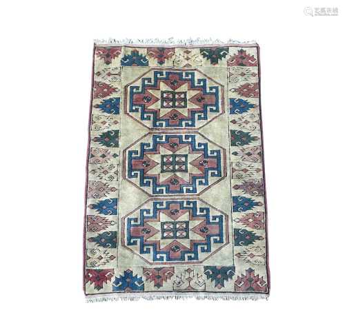 A Turkish rug, late 20th century, the ivory field with three...
