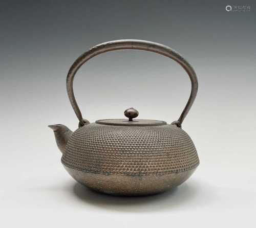 A Japanese iron teapot, 19th century, character marks by spo...