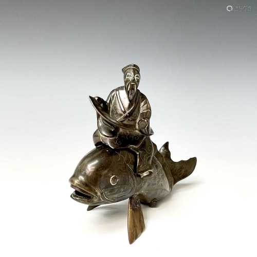 A Chinese bronze and white metal inlaid group of a sage upon...