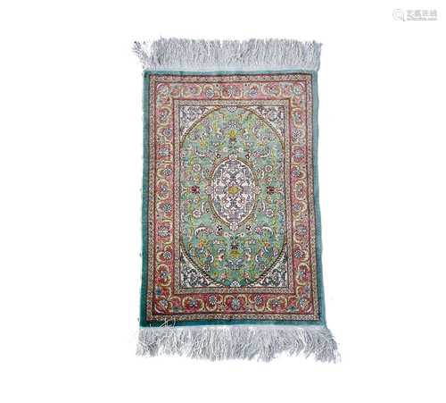 A Turkish silk rug, the pale blue field with an oval ivory m...