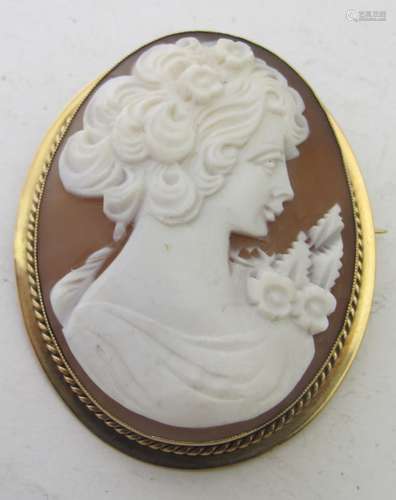 A 9ct gold cameo brooch/pendant depicting a lady with flower...