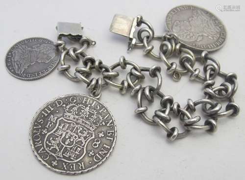 A white metal link bracelet with three reproduced coins, ind...