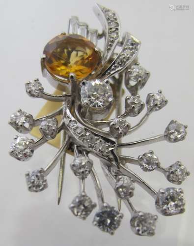 A stylised foliate spray clip brooch set with a round shape ...