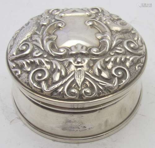 A silver trinket box in the Victorian style, embossed with m...