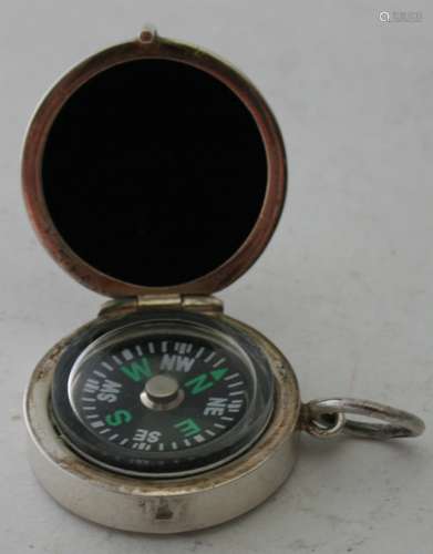 A small white metal cased compass, engraved F T. Condition r...