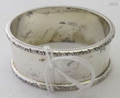 A plain oval silver napkin ring with chased edging, Birmingh...