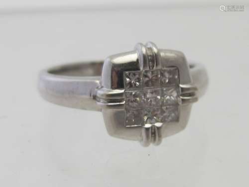 An 18ct white gold square set ring, set with a block of nine...