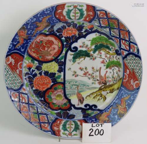 A large antique Japanese porcelain charger with crane and dr...