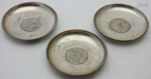 A collection of three silver dishes, all inset with Churchil...