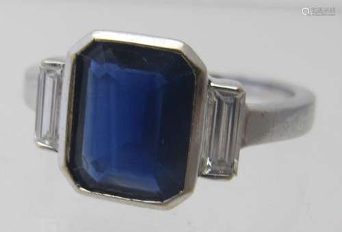 An 18ct white gold emerald cut sapphire & diamond ring.