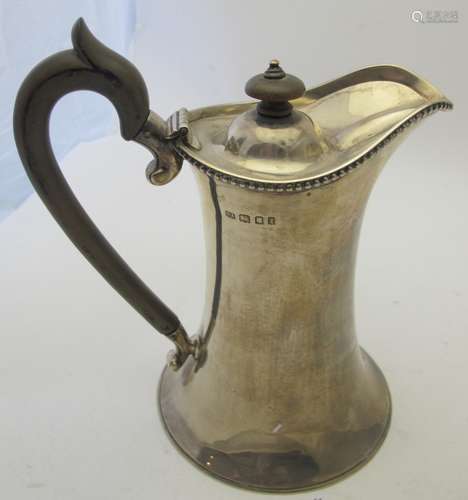 An elegant shaped silver hot water jug with bead edge decora...