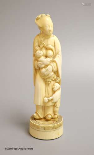 A Japanese ivory okimono of a lady feeding a child, Meiji pe...