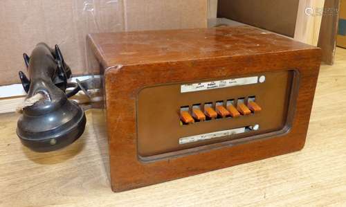 A vintage walnut-cased telephone switchboard with black Bake...