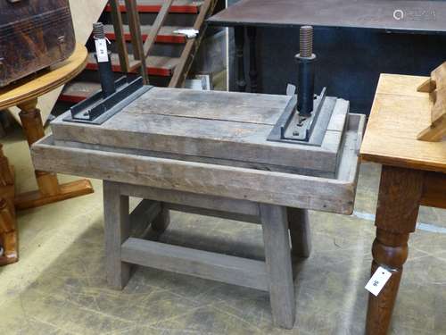 An antique wood and cast iron twin-screw cider press on stan...