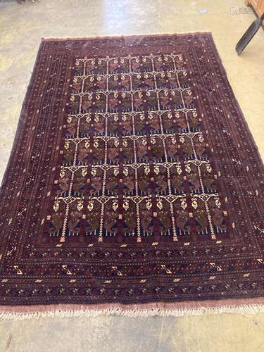 An Eastern dark red and blue ground carpet with central pole...