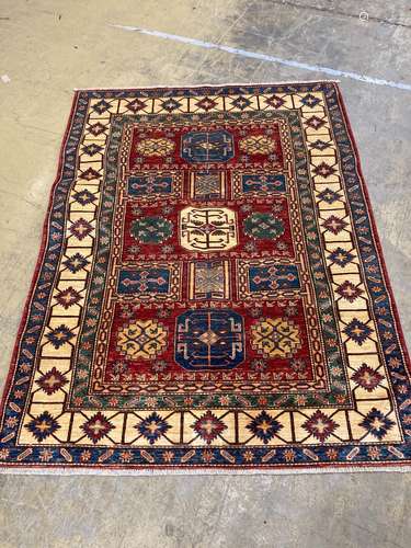 A Caucasian design red ground rug with geometric motifs with...