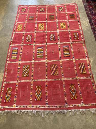 A Moroccan red ground rug,decorated with geometric panels, 2...