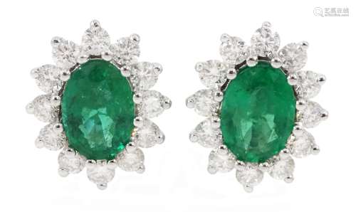 Pair of 18ct white gold oval emerald and diamond cluster stu...