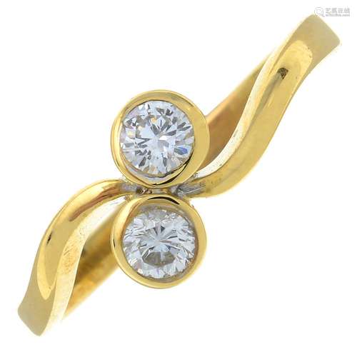 An 18ct gold brilliant-cut diamond two-stone crossover ring....