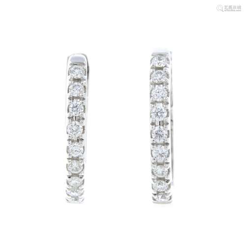 A pair of brilliant-cut diamond hoop earrings.Total diamond ...