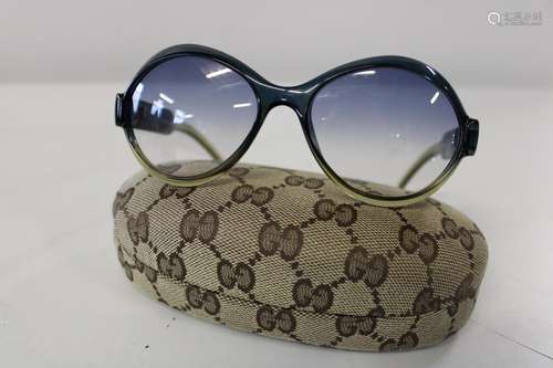 A pair of Gucci sunglasses with original case.