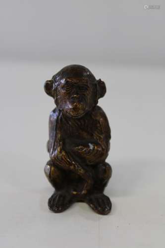 A 19th century carved stone monkey, bronze in colour 6cm