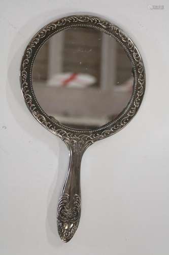 A vintage white metal hand held mirror