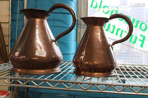 Two graduated copper jugs h29cm & h25cm