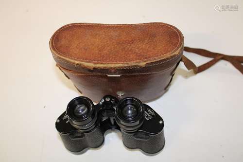 A cased pair of Dollands field binoculars