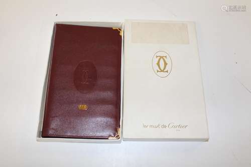 A Cartier signature red leather card wallet with gilt corner...