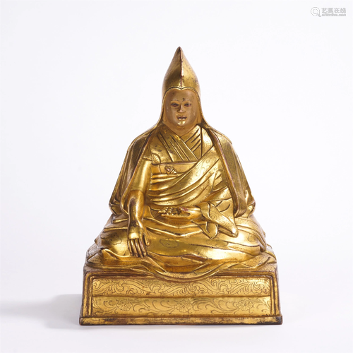 A TIBETAN GILT BRONZE SEATED MASTER GURU