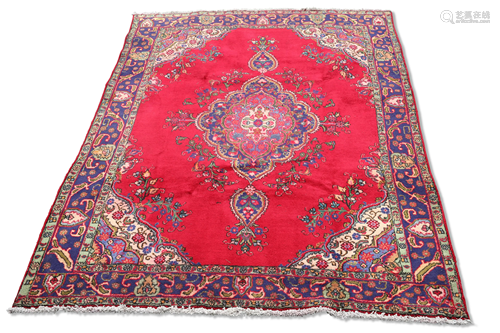 A PERSIAN TABRIZ CARPET, the rich red ground with