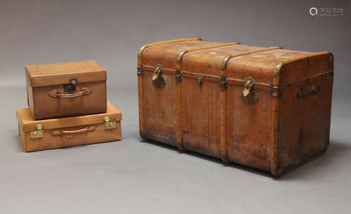 A large tan leather and oak bound trunk, early 20th Century,...