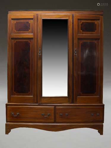 An Edwardian mahogany and crossbanded triple wardrobe, the c...