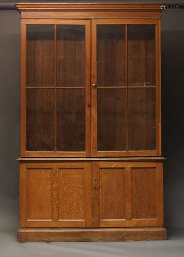 A late Victorian oak bookcase, with glazed doors enclosing f...