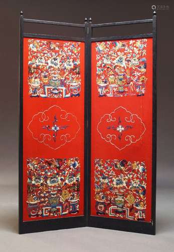 A Chinese ebonised two fold screen, 20th Century, with red f...