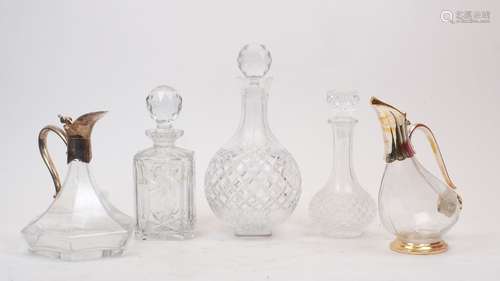 Three clear glass decanters and two ewers, 20th century, the...