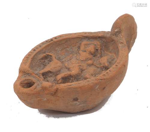 A Roman style terracotta oil lamp, 20th century, with tablea...