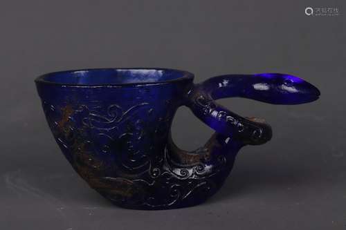 A BLUE GLASS RELIEF-DECORATED CUP