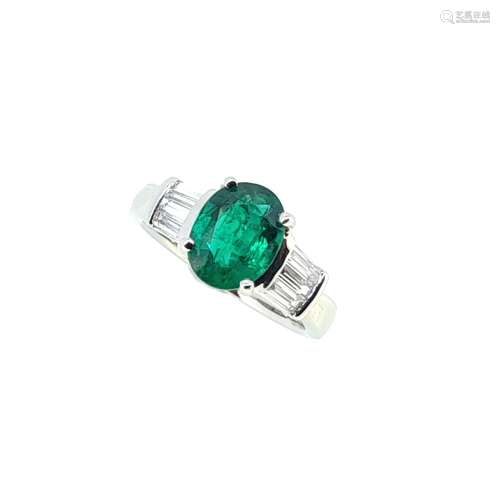 An emerald and diamond ring set in platinum,