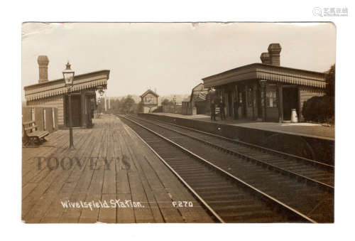 A photographic postcard titled 'Wivelsfield Station', showin...