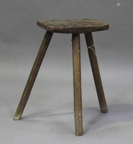 An 18th century primitive elm stool with staked legs, height...