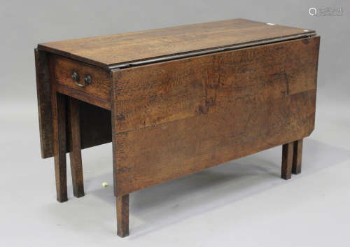 A George III provincial oak drop-flap dining table, fitted w...