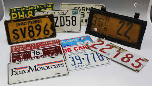 A group of mainly American car registration plates and holde...