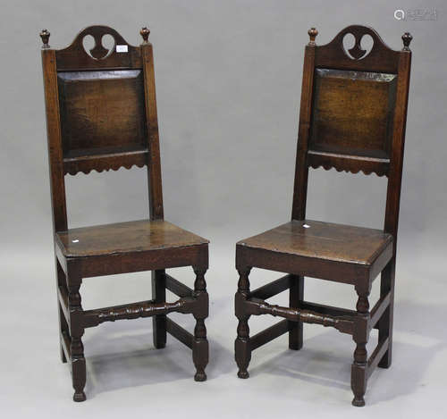 A pair of late 17th century oak panel back chairs with pierc...