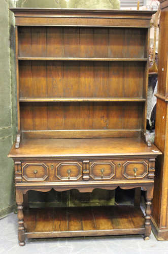 A 20th century Jacobean Revival oak dresser, the shelf back ...