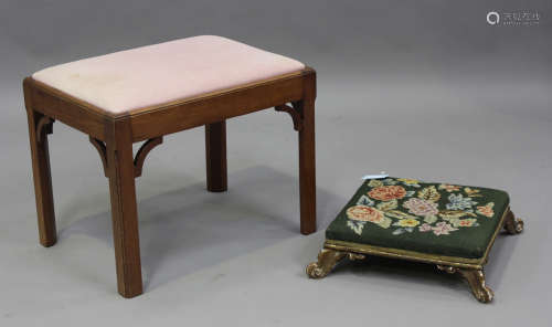 A late Victorian carved giltwood footstool, on carved scroll...